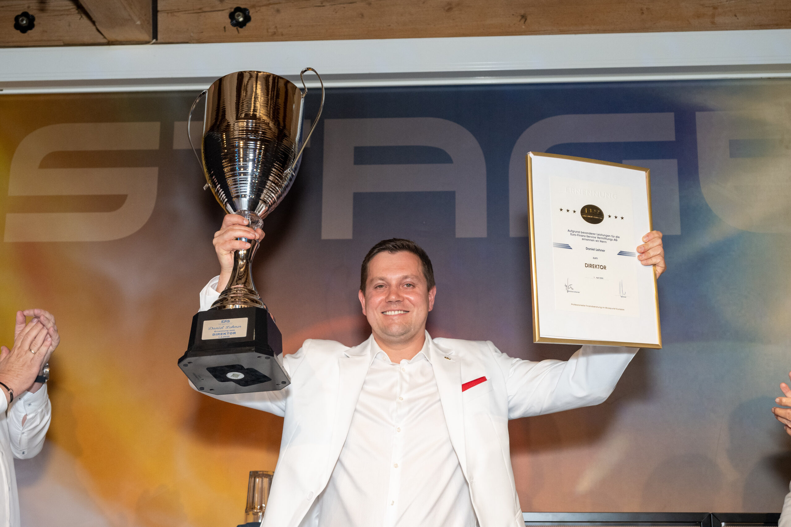 Mann hat seine Beförderung erhalten. Erhält Pokal und Auszeichnung in der Hand.