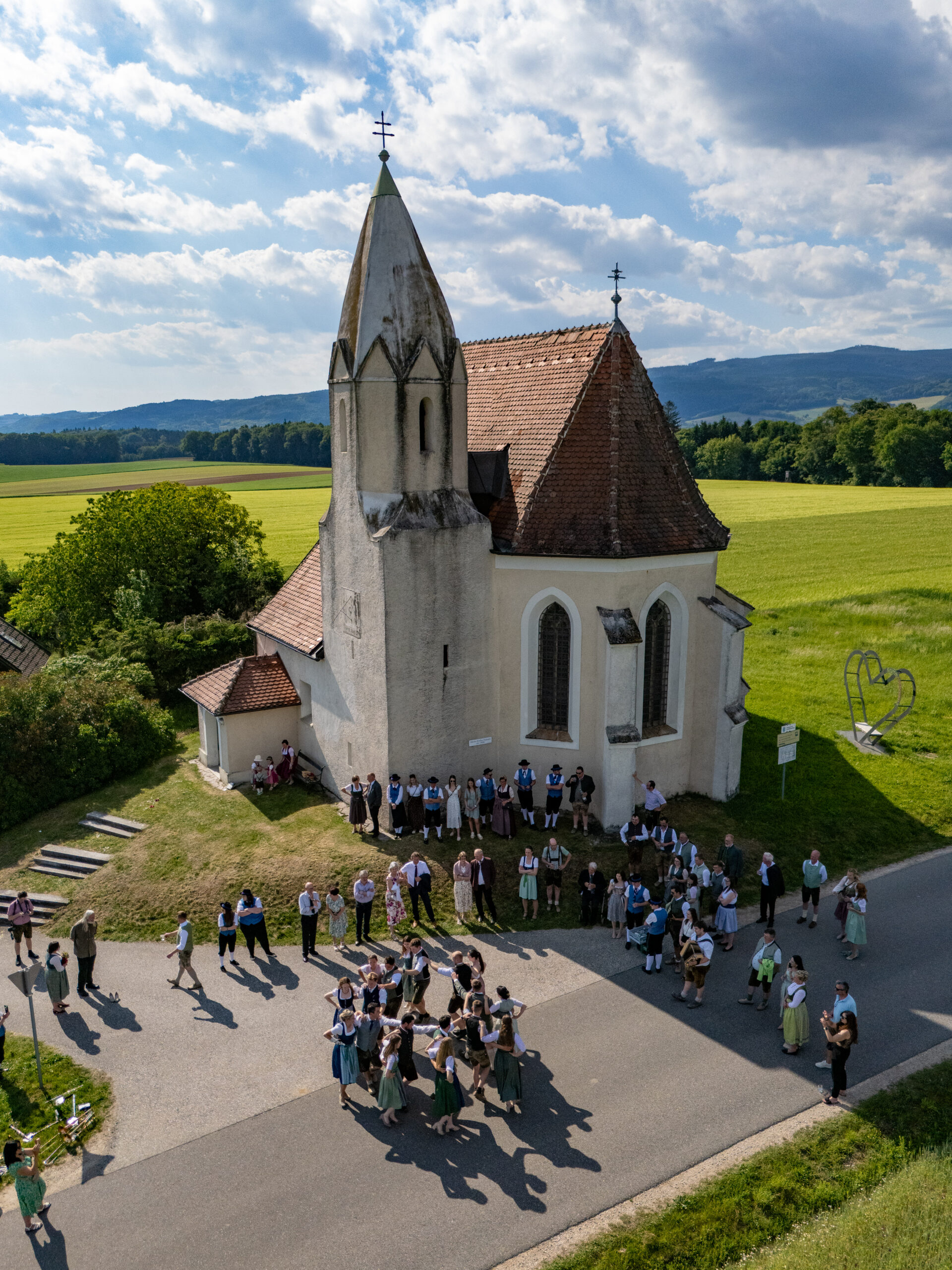 Hochzeitsgesellschaft ist am Tanzer auf einer Verlassenen Straße - vor der Kirche - Foto mit der Drohne gemacht