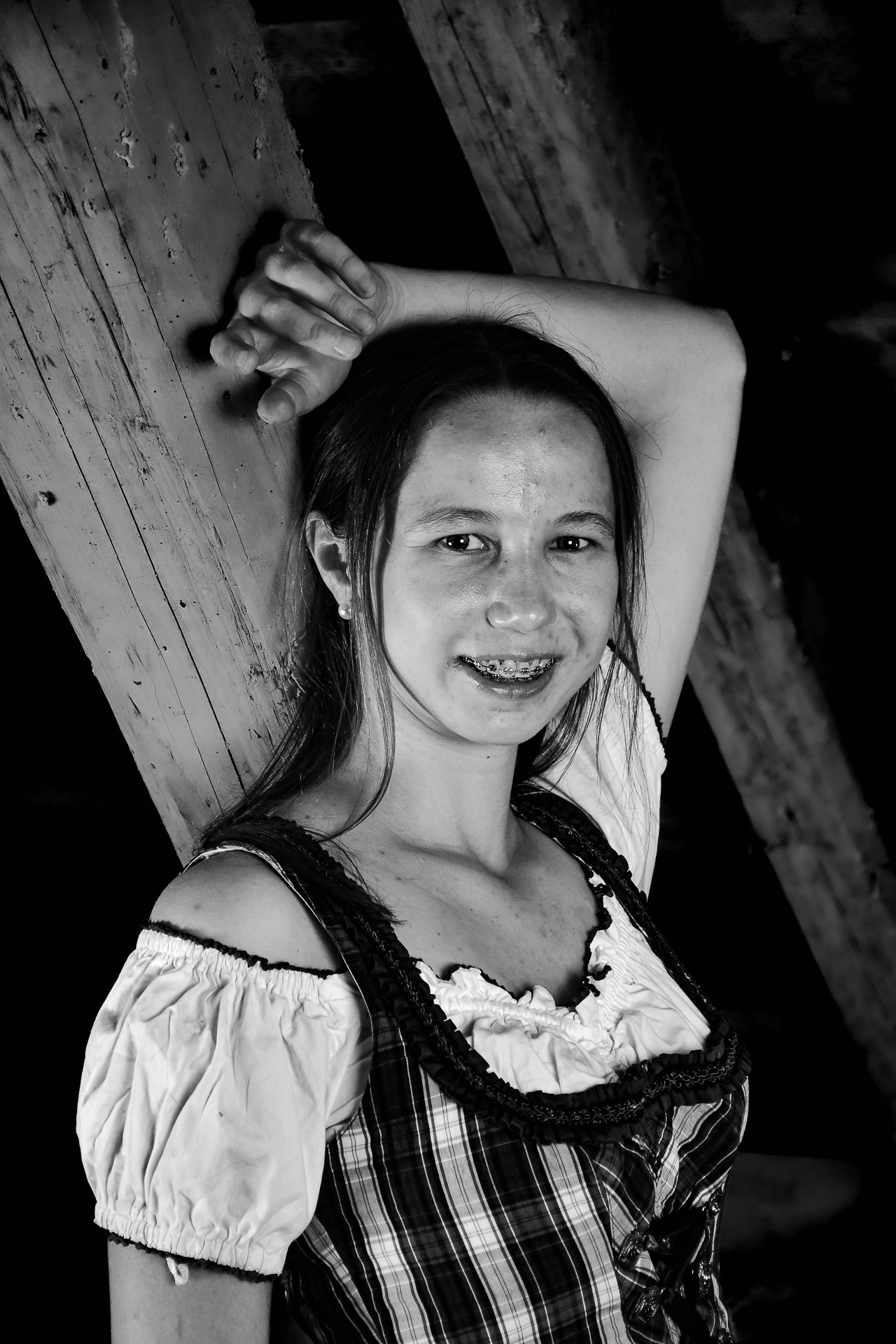 Model lehnt an einem Holzbalken