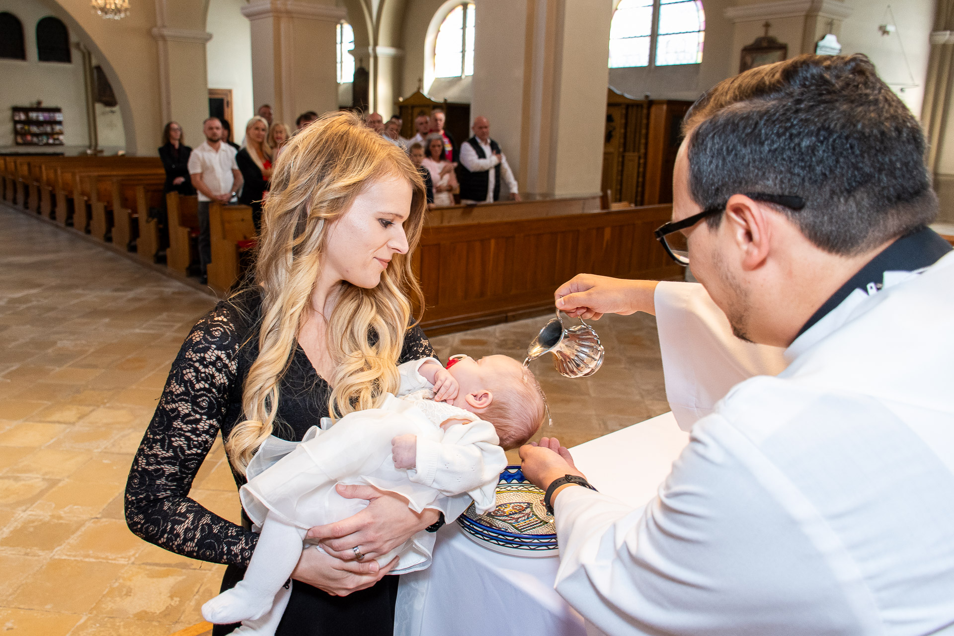 Baby wird mit Weihwasser übergossen